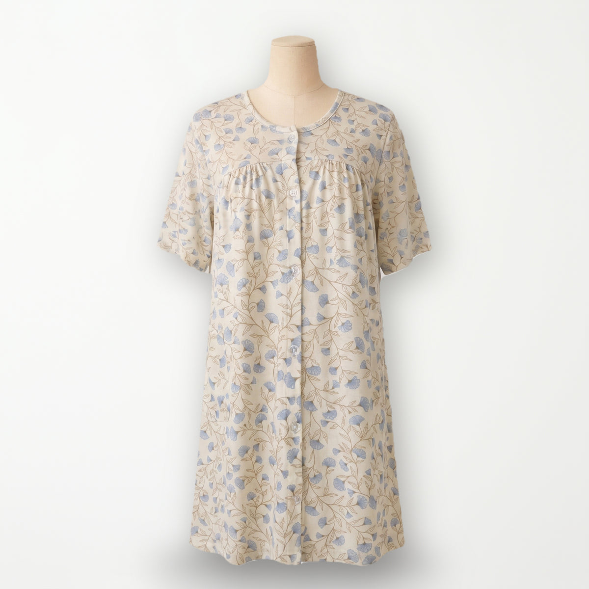 Bata clásica Campanilla, crema con flores azules y botonadura entera, vista completa